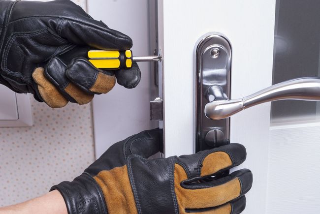 Gloved hands installing a silver door handle